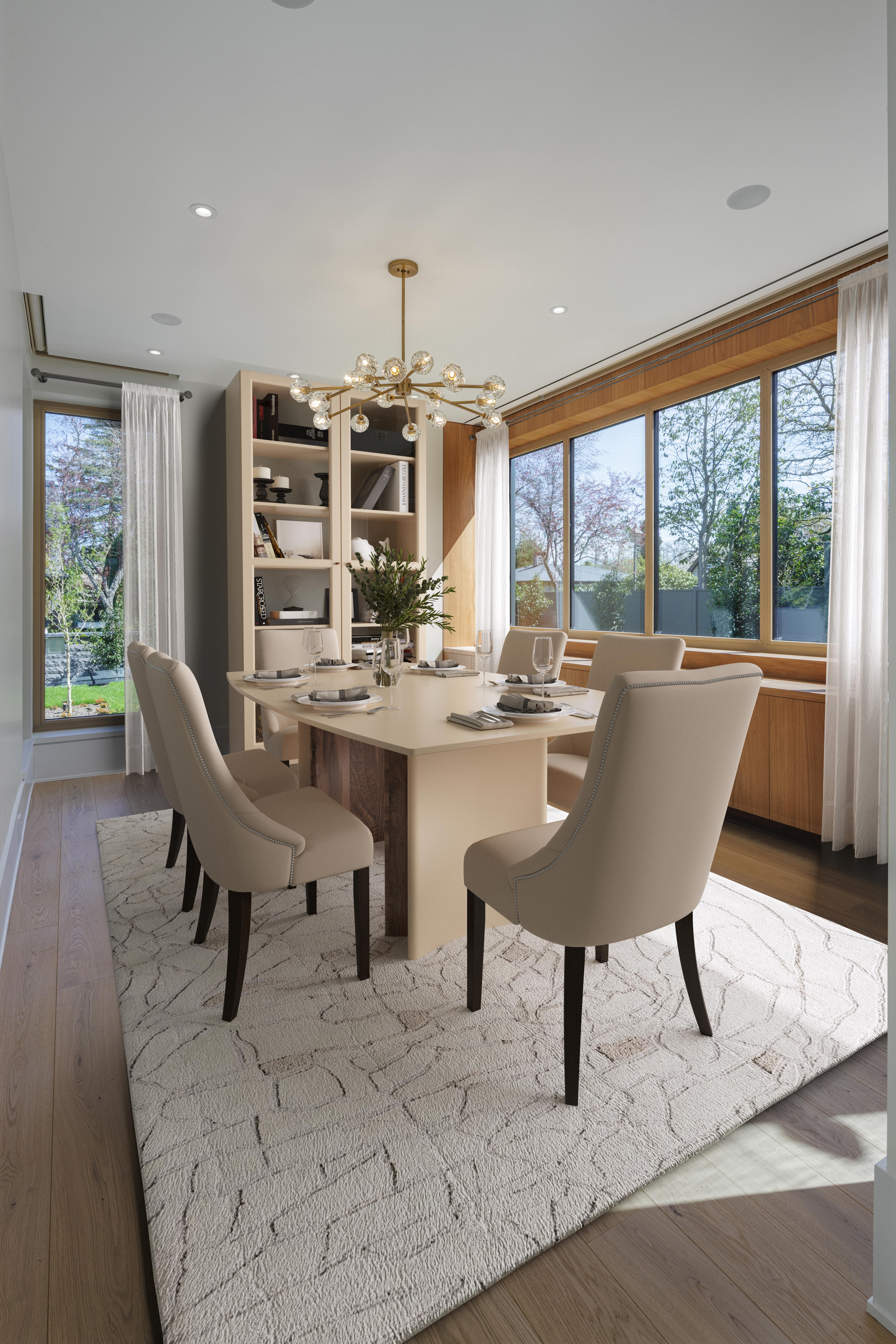 Elegant dining room by a leading British Columbia general contractor features beige chairs, a light rug, large windows, and a gold chandelier.