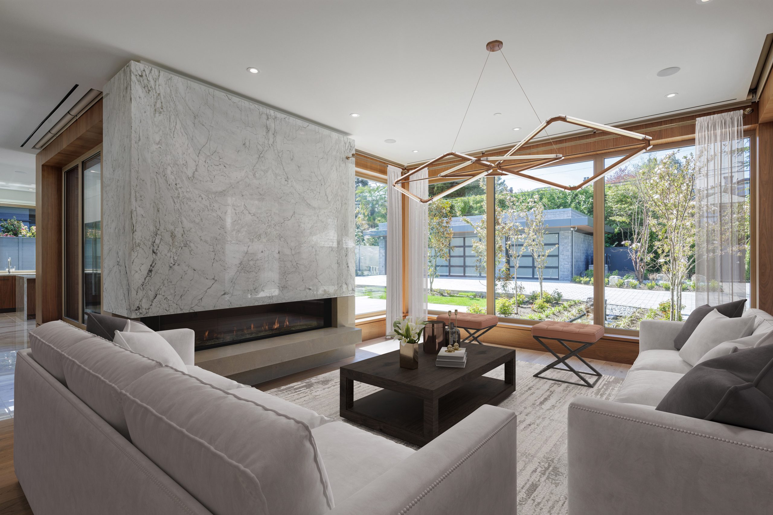 Living room with white sofas, marble fireplace, large windows, and a view of a lush British Columbia garden outside.