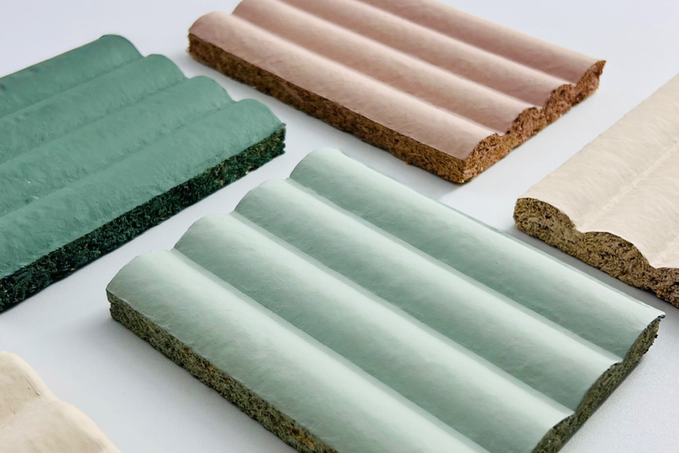 Textured, wavy tiles in pastel tones of green, pink, and cream arranged on a white surface.
