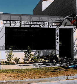 Office building with Kindred Developments Ltd. sign above dark windows and address number 1747 by the entrance.